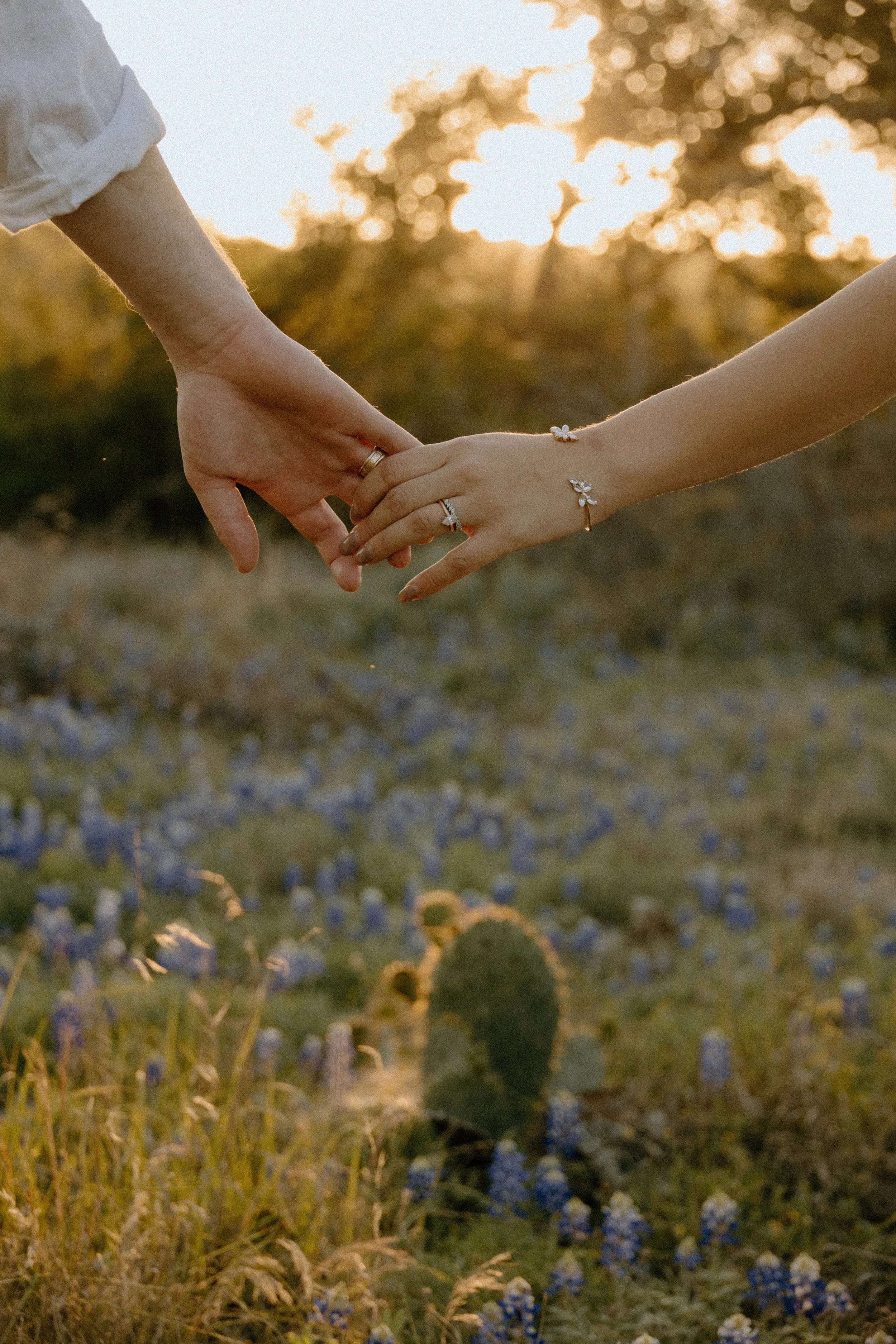 Houston & Texas Family, Couples, Newborn, Maternity, Bridal Photography – Sunlit hand-holding moment in Austin TX meadow engagement session.