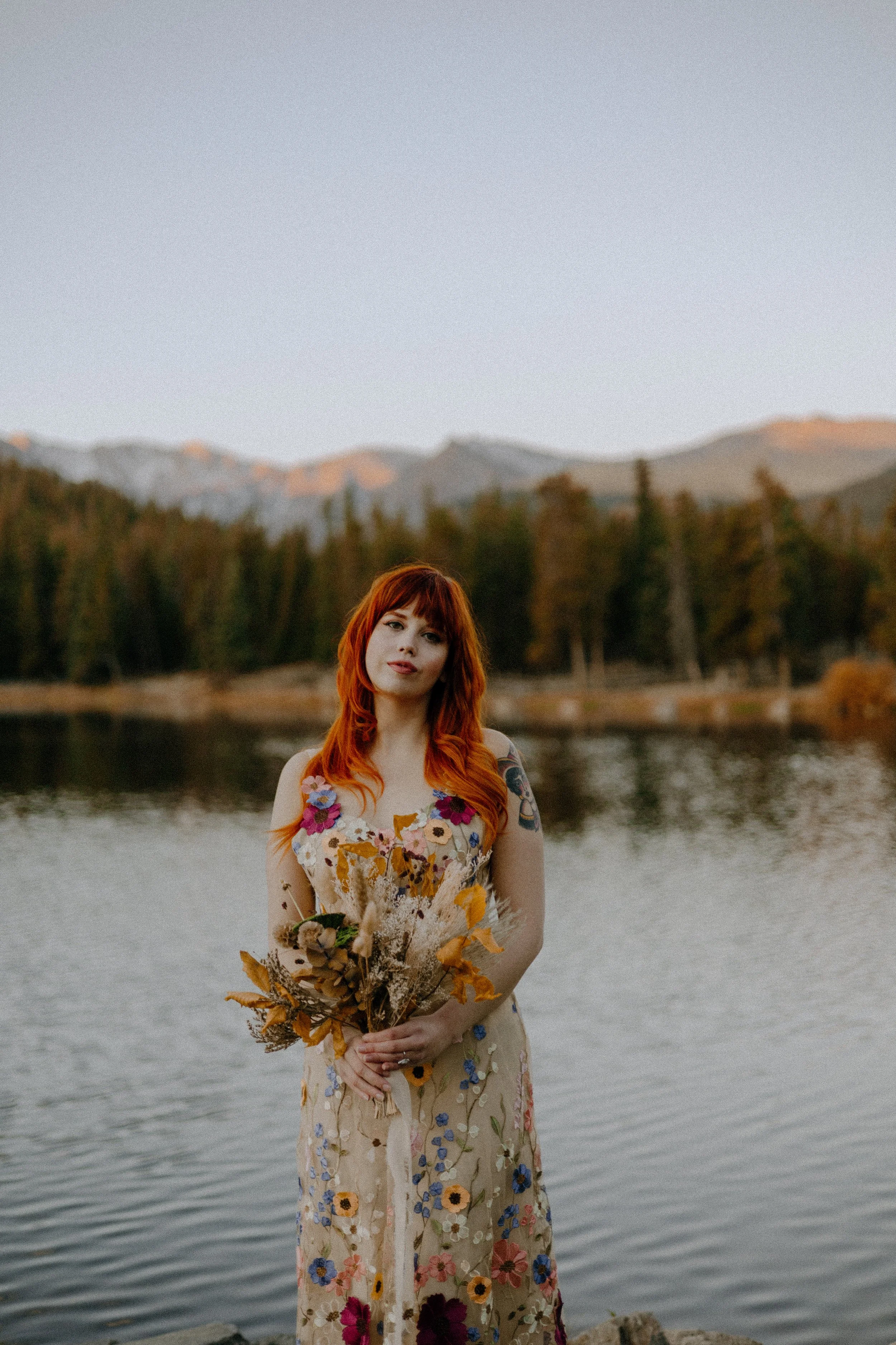 Houston & Texas Wedding & Elopement Photography – Bride standing by alpine lake with bouquet at Echo Lake Colorado.