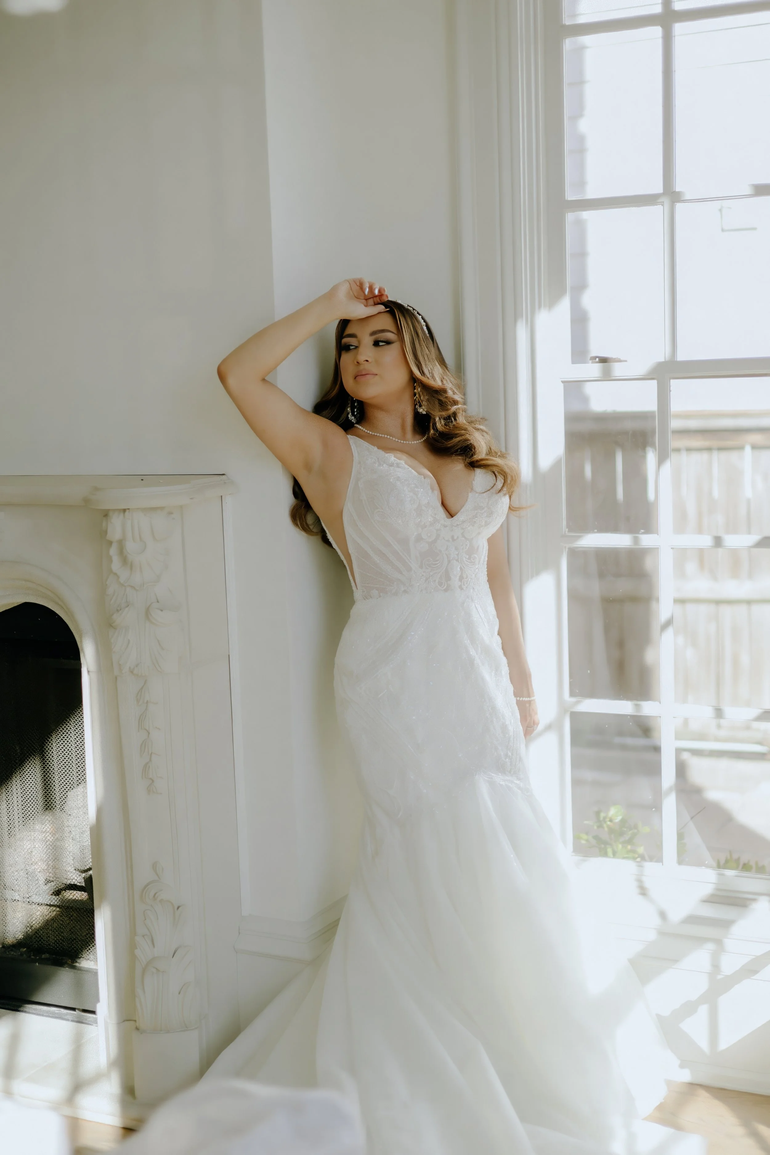Houston & Texas Family, Couples, Newborn, Maternity, Bridal Photography – Bride posing in sunlight by white fireplace in Houston studio.