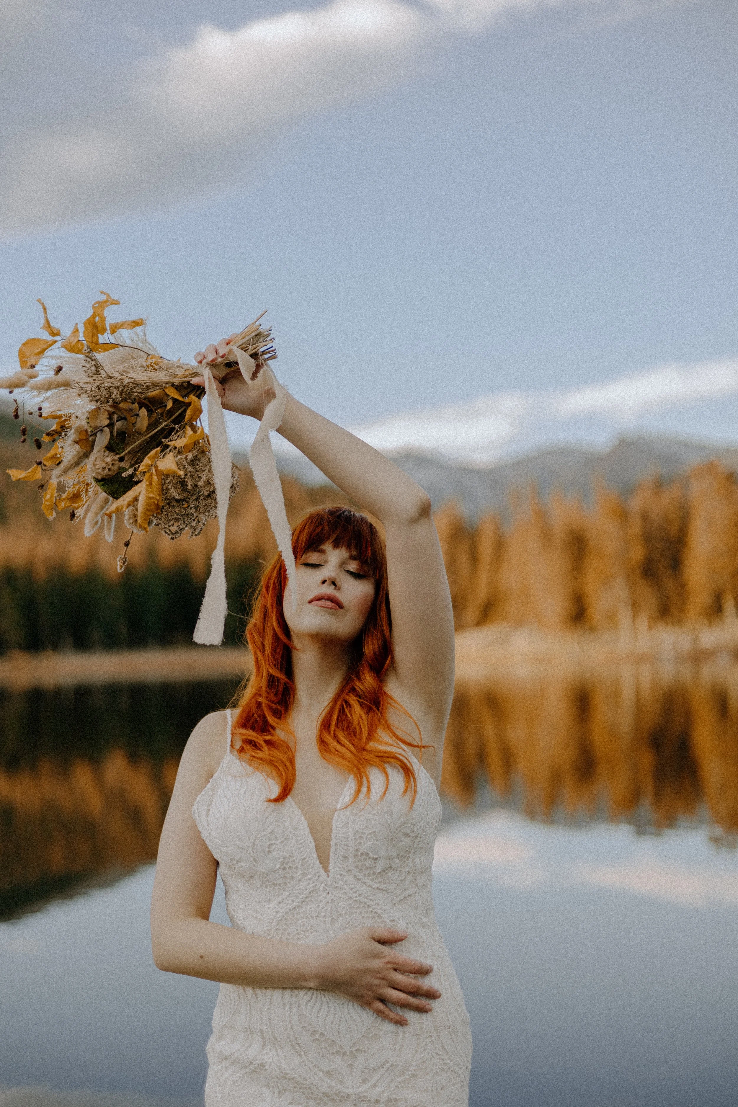Houston & Texas Wedding & Elopement Photography – Bride raising bouquet triumphantly with golden foliage backdrop at Echo Lake.