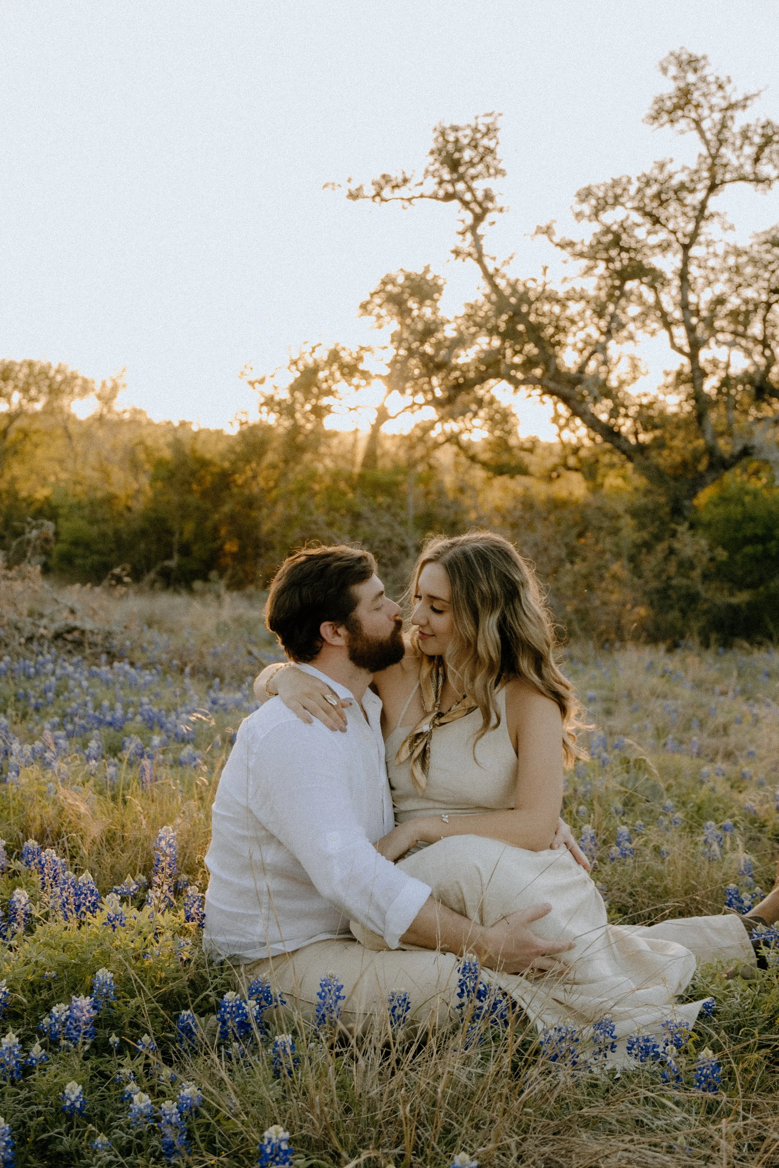 Houston & Texas Family, Couples, Newborn, Maternity, Bridal Photography – Couple seated with wildflower background, Austin TX outdoor portraits.