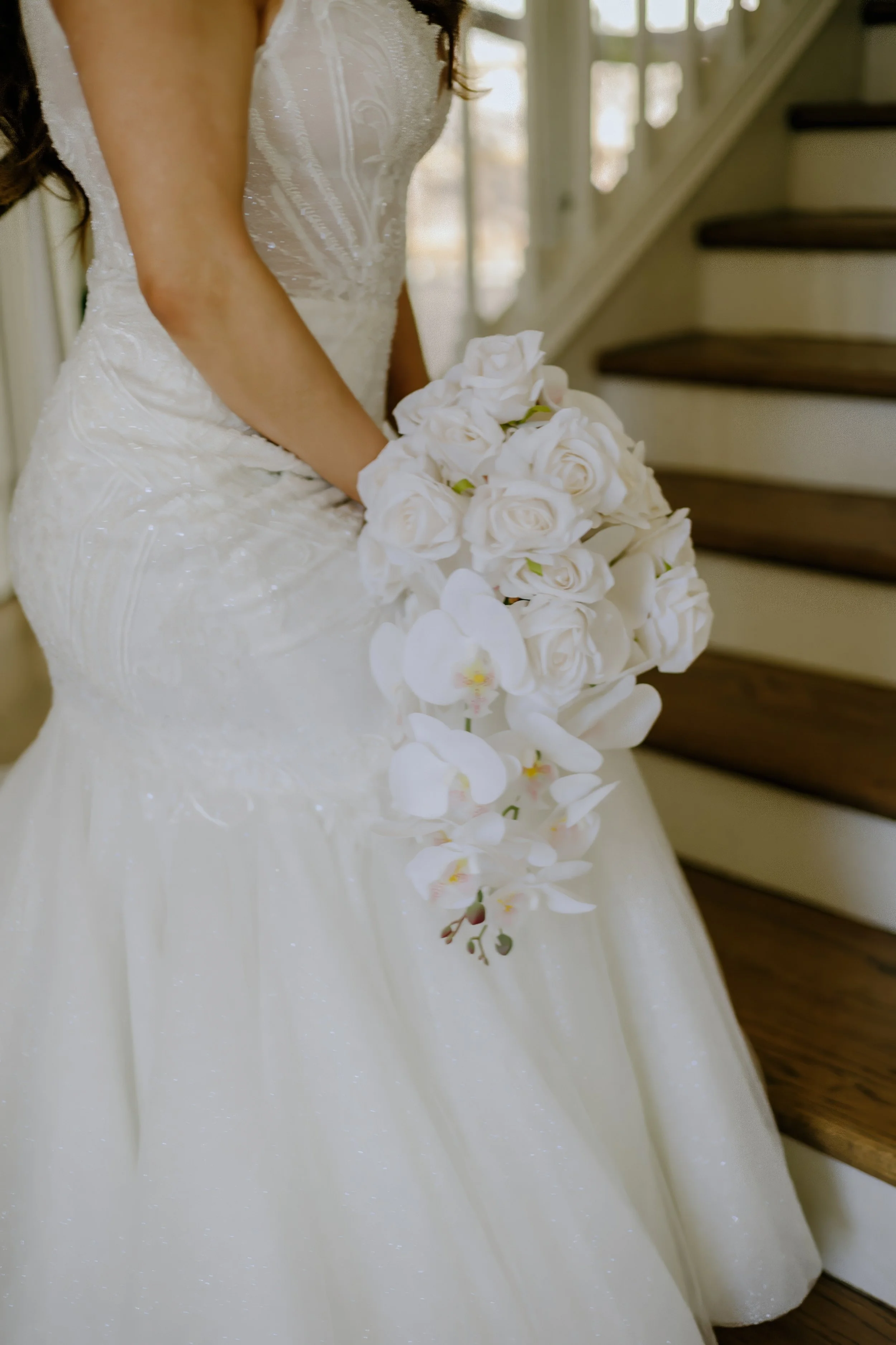 Houston & Texas Family, Couples, Newborn, Maternity, Bridal Photography – Bride adjusting lace gown with bouquet in hand, Houston studio.