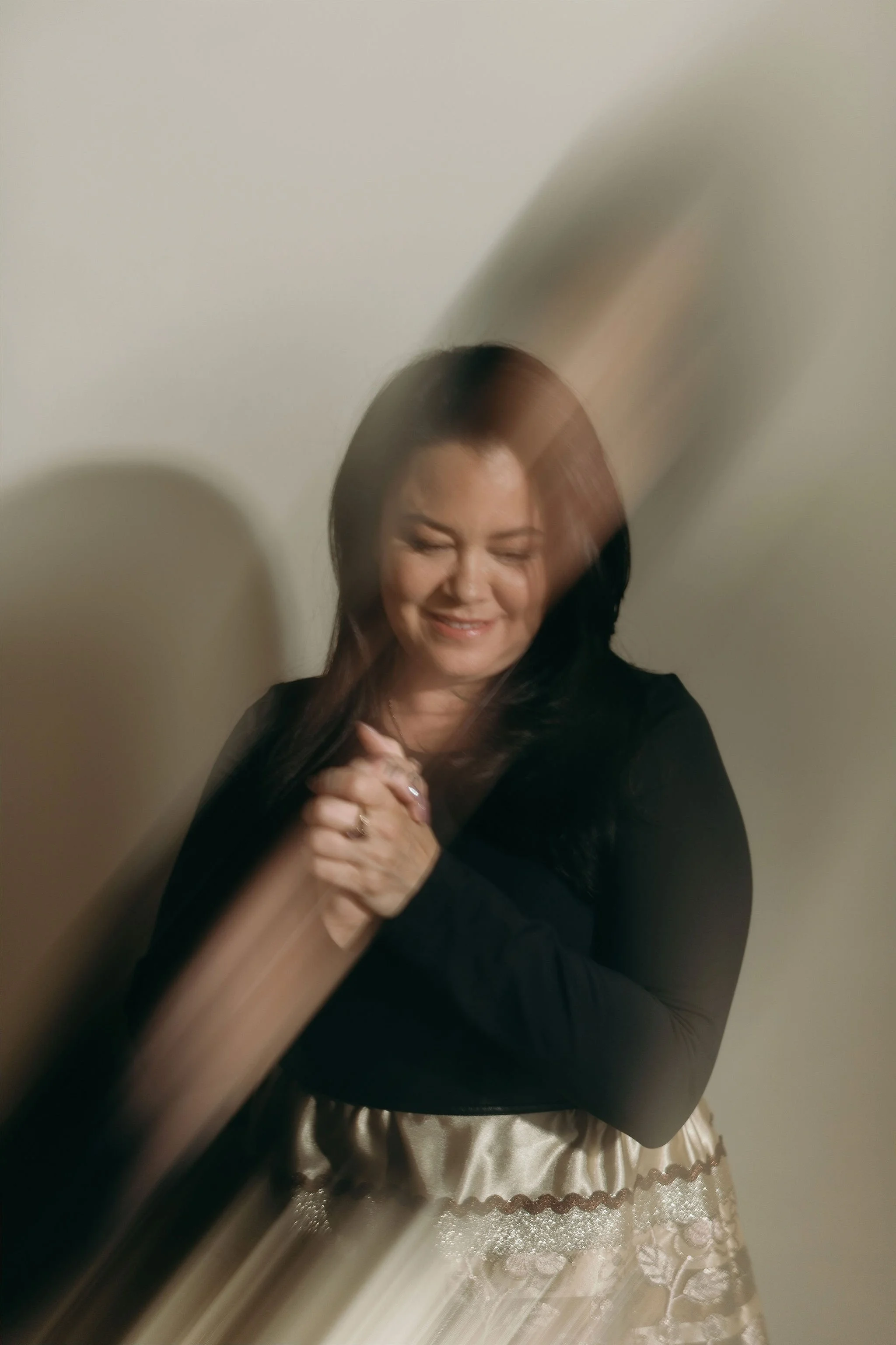 Danielle Searancke, the Squamish Medium, clasps her hands and smiles while looking down