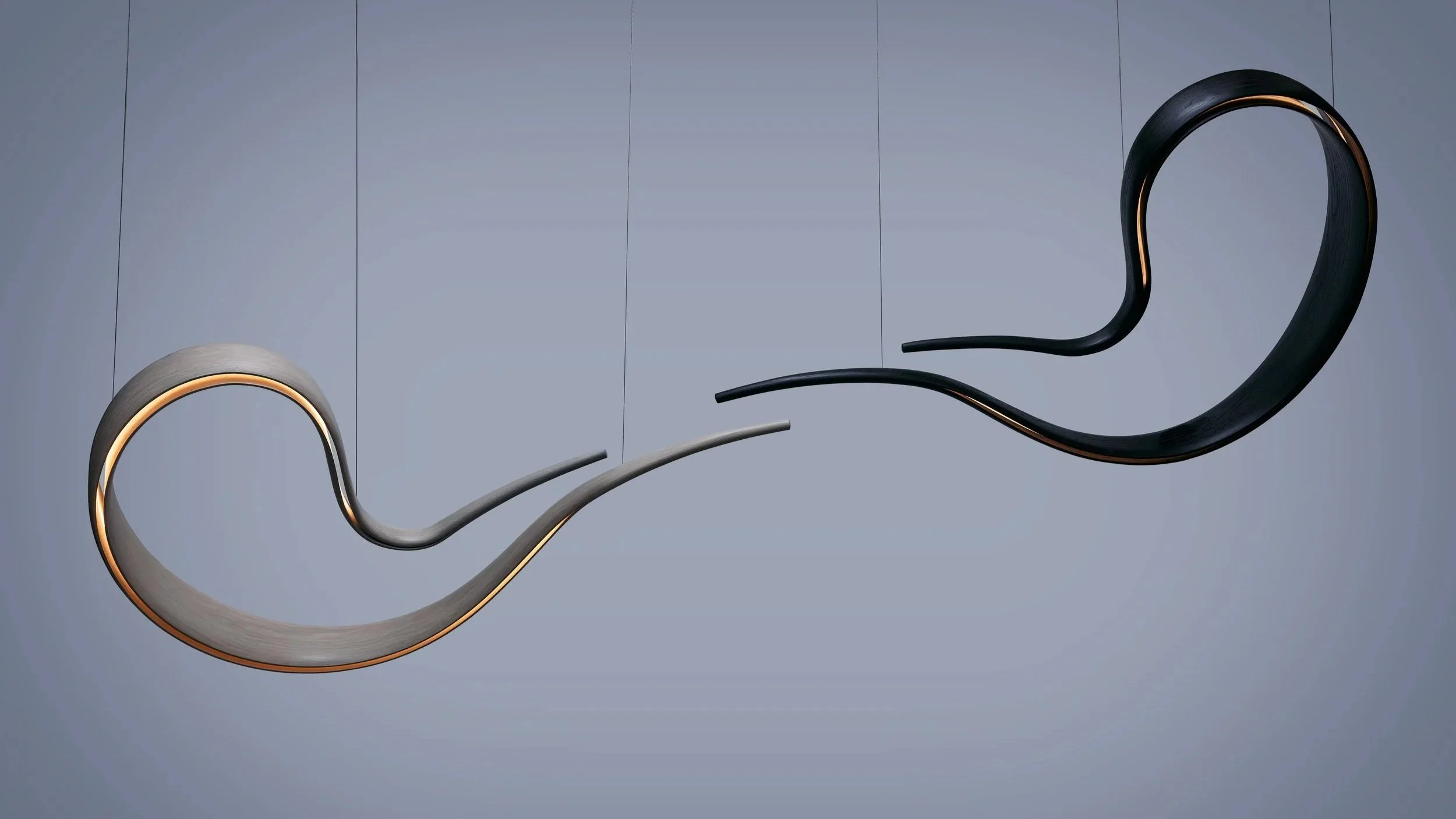 Suspended sculptural lighting installation with illuminated organic wood forms.