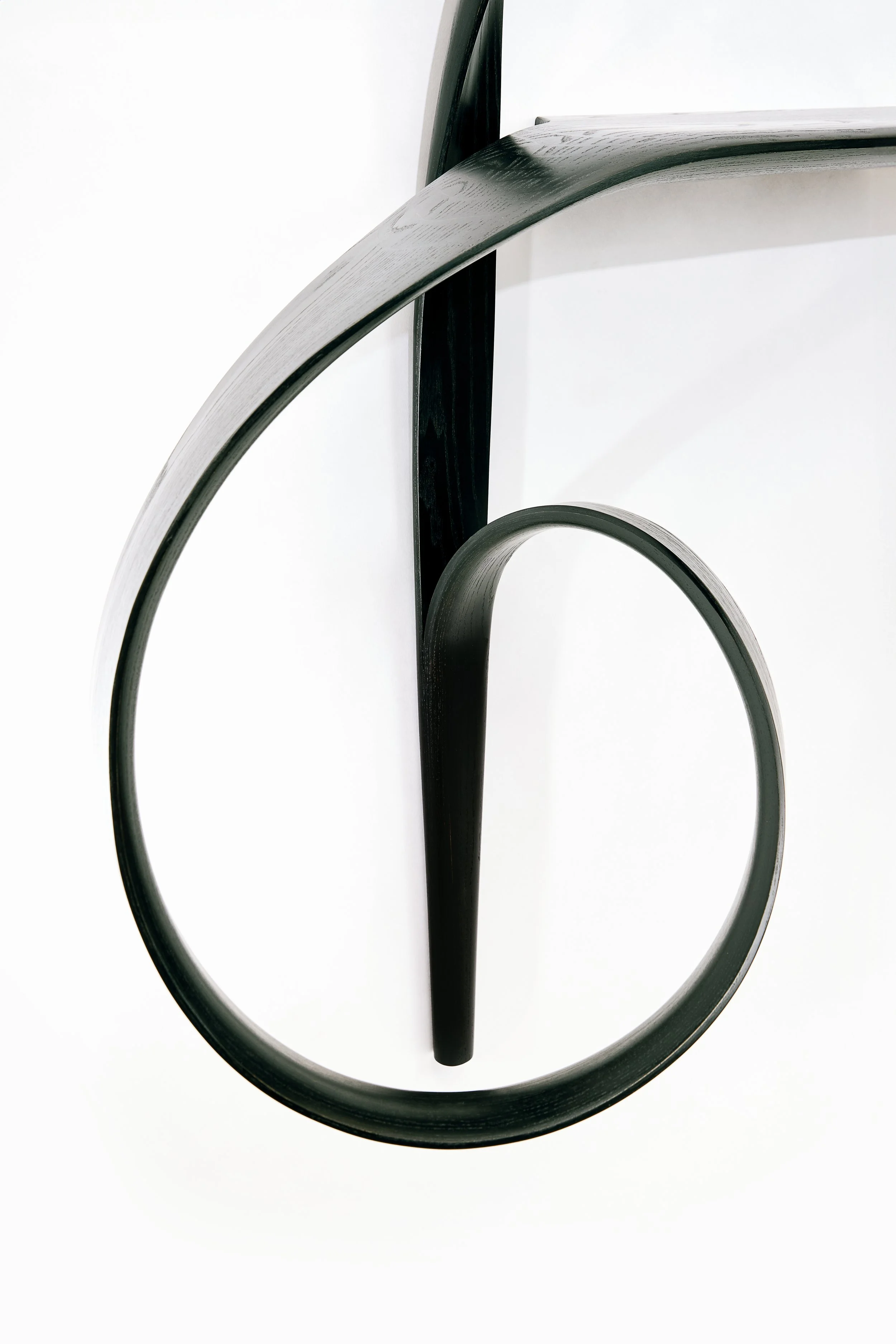 “Detail view of the Emovere bent wood wall sculpture by Adam Bentz featuring curved ribbon forms and minimalist architectural lines.”