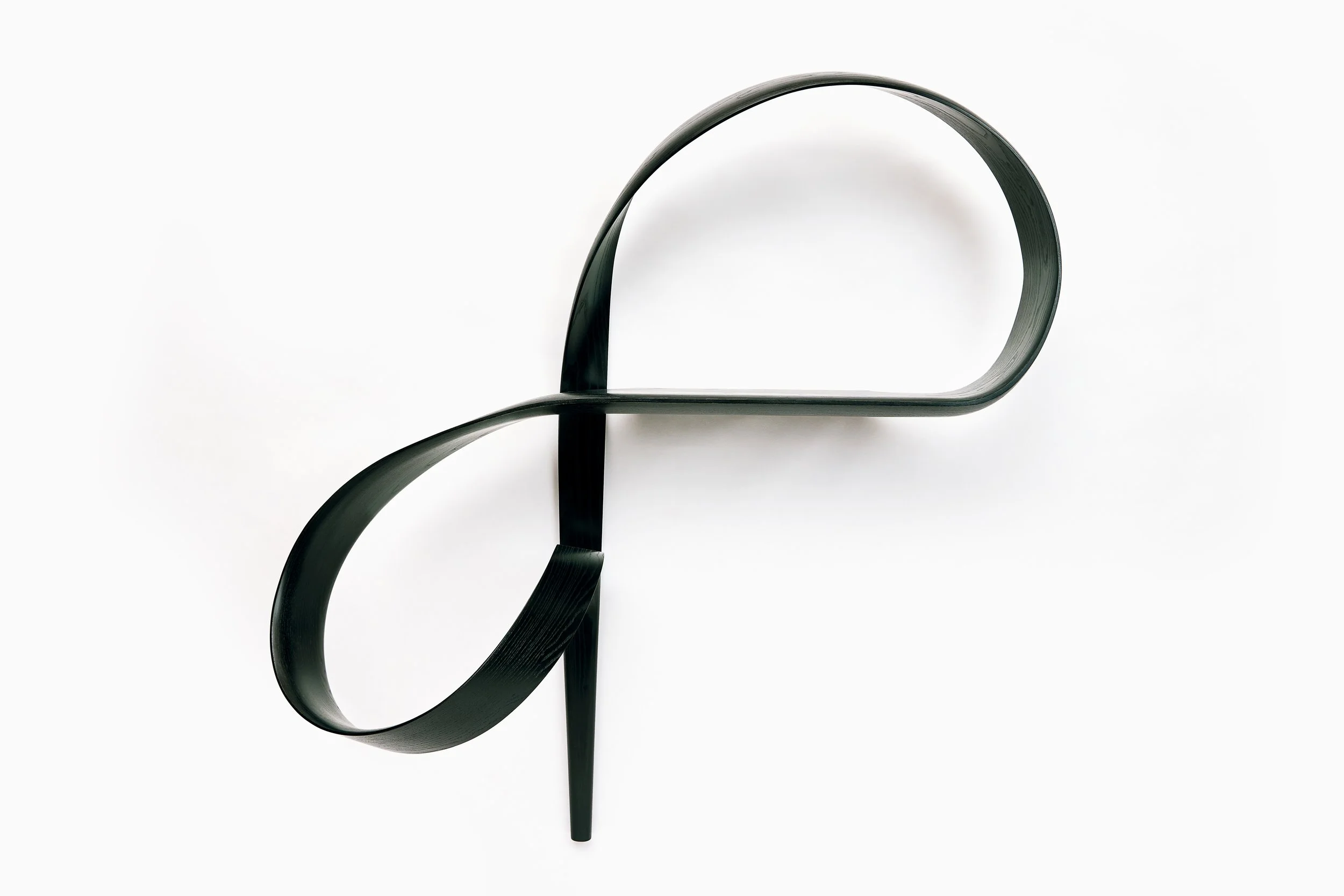 “Emovere bent wood wall sculpture by Adam Bentz featuring looping architectural ribbon forms in a minimalist blackened composition.”
