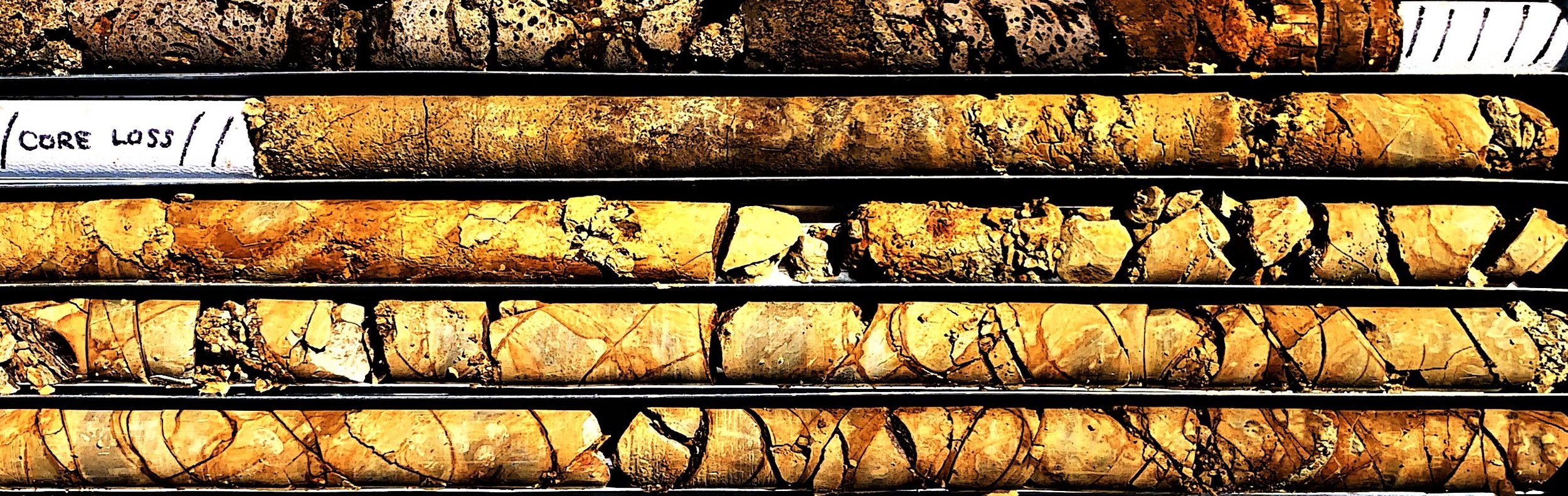 A collection of rock core samples in different stages of weathering, with a handwritten label 'ORE LOSS' on the top left.