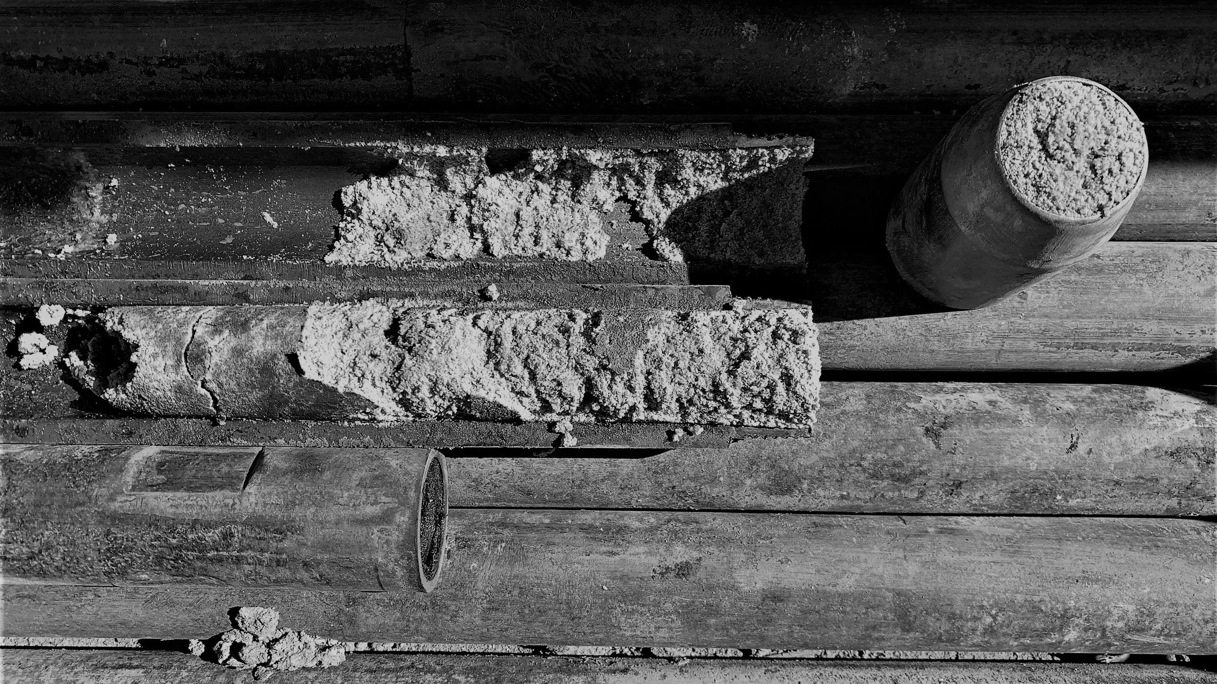 Black and white photo of a Standard Penetration Testing split spoon containing a sample of sand