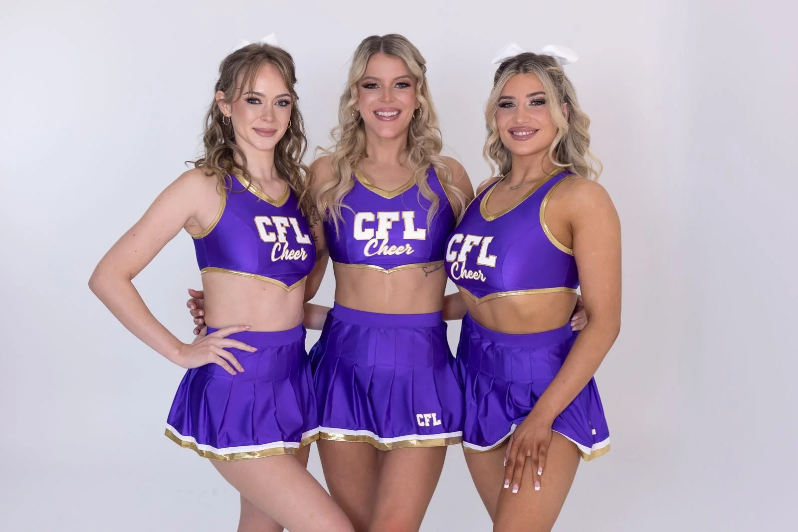 Three Centrefold showgirls in purple CFL cheer uniforms at Centrefold Lounge