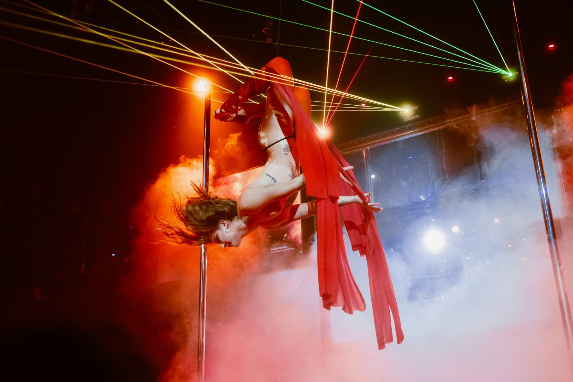 Aerial performer above the Centrefold stage with colourful laser lighting