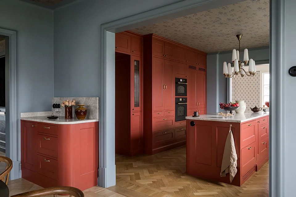 Platsbyggt klassiskt lantkök i modern utformning och funktion. Modernt rundade former. Köket i djupa varma toner av rött och duvblått på väggar och lister.