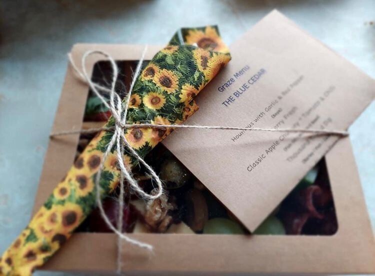 grazing box showing packaging, menu and wrapped knife fork and spoon
