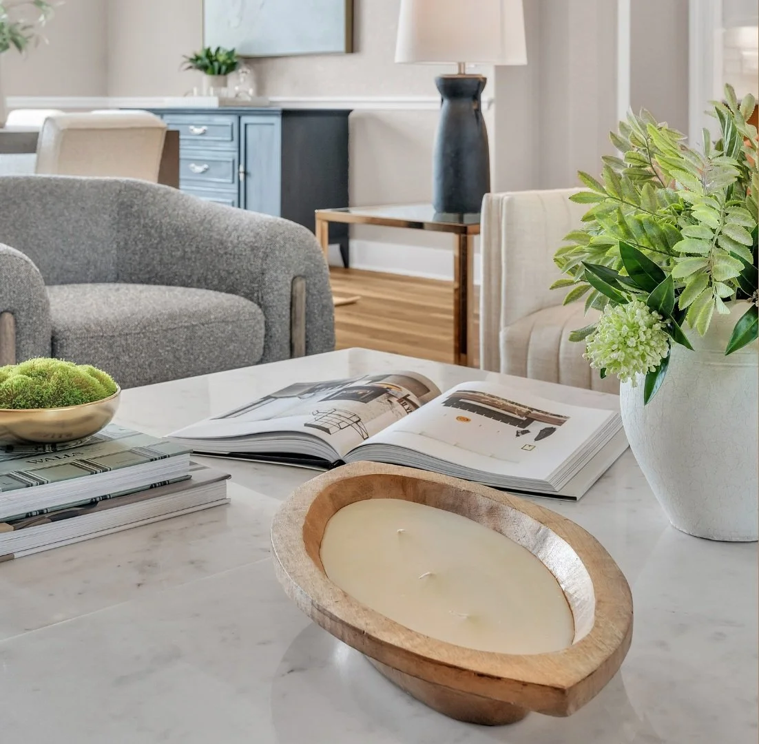 Styled coffee table with a candle, plants, and books