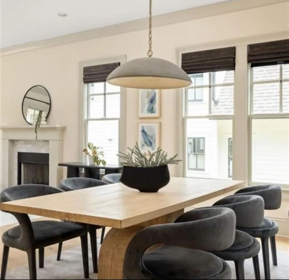 Cool toned dining room with 6 chairs and a light wood table