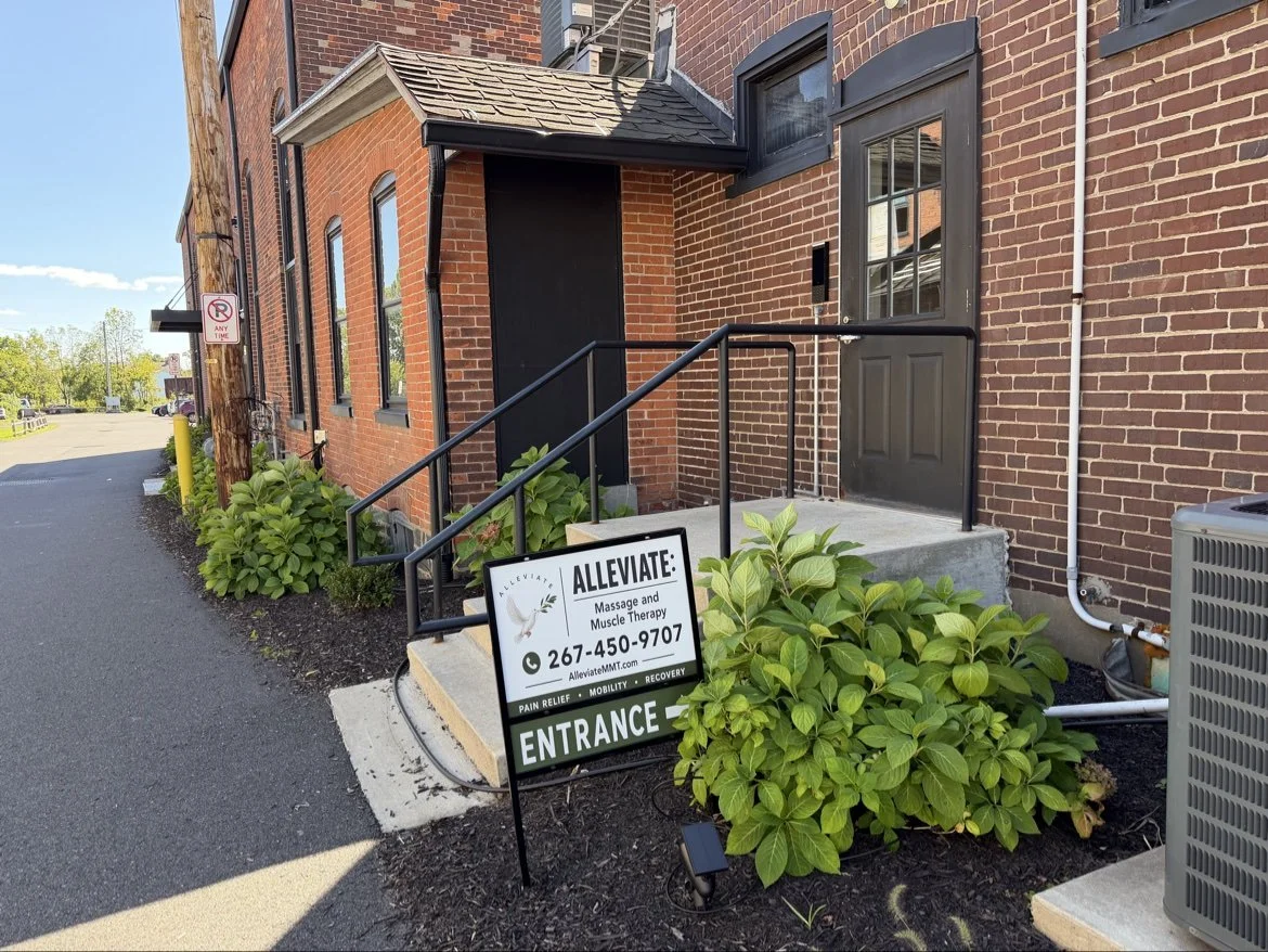 The side entrance to ALLEVIATE in Quakertown, with the door, steps, and ALLEVIATE entrance sign