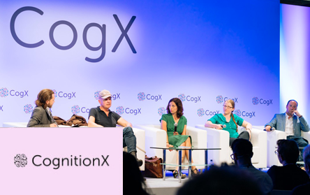 Photograph from CogX conference and a 5-people panel discussion on a stage with CogX logo on the background