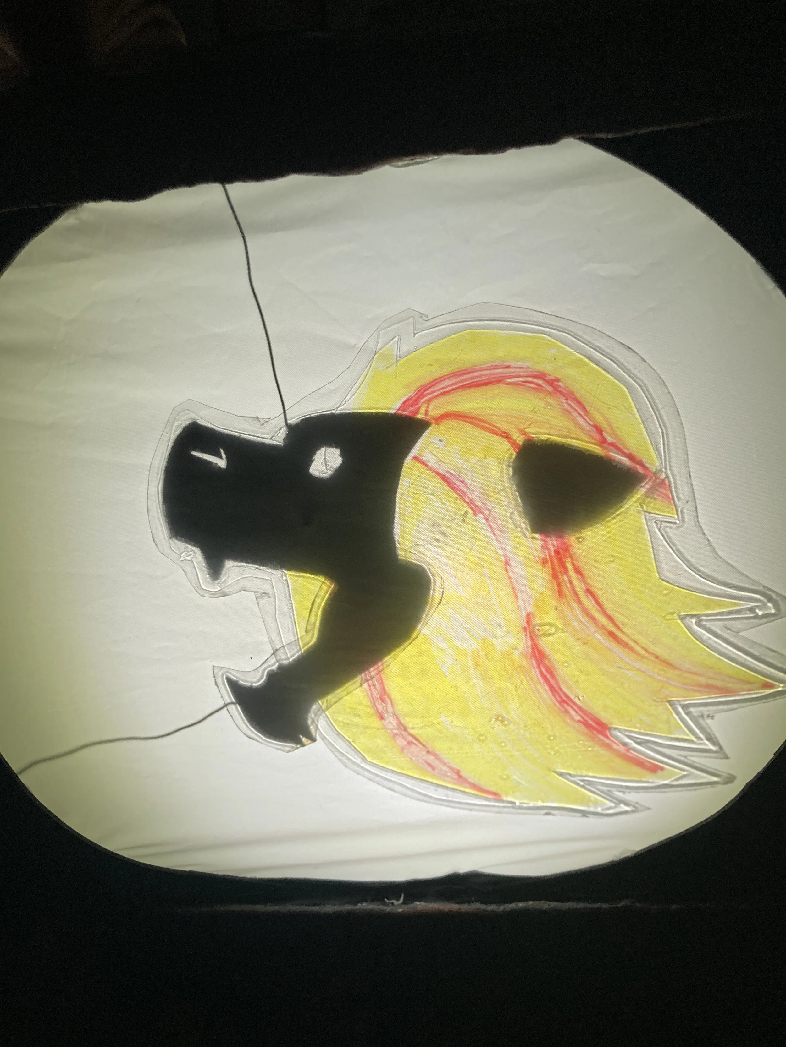 Alt Text:A lion shadow puppet with a gold and red main roaring