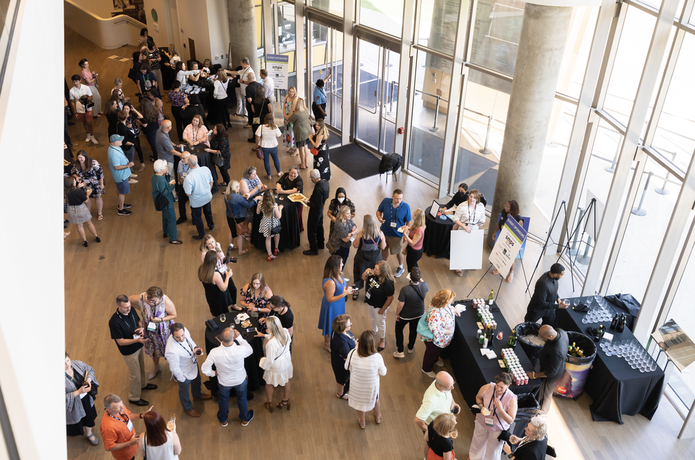 Overhead view of attendees networking in a sunlit event atrium