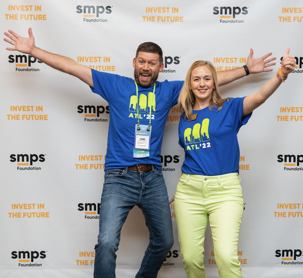 SMPS attendees celebrating with their arms raised