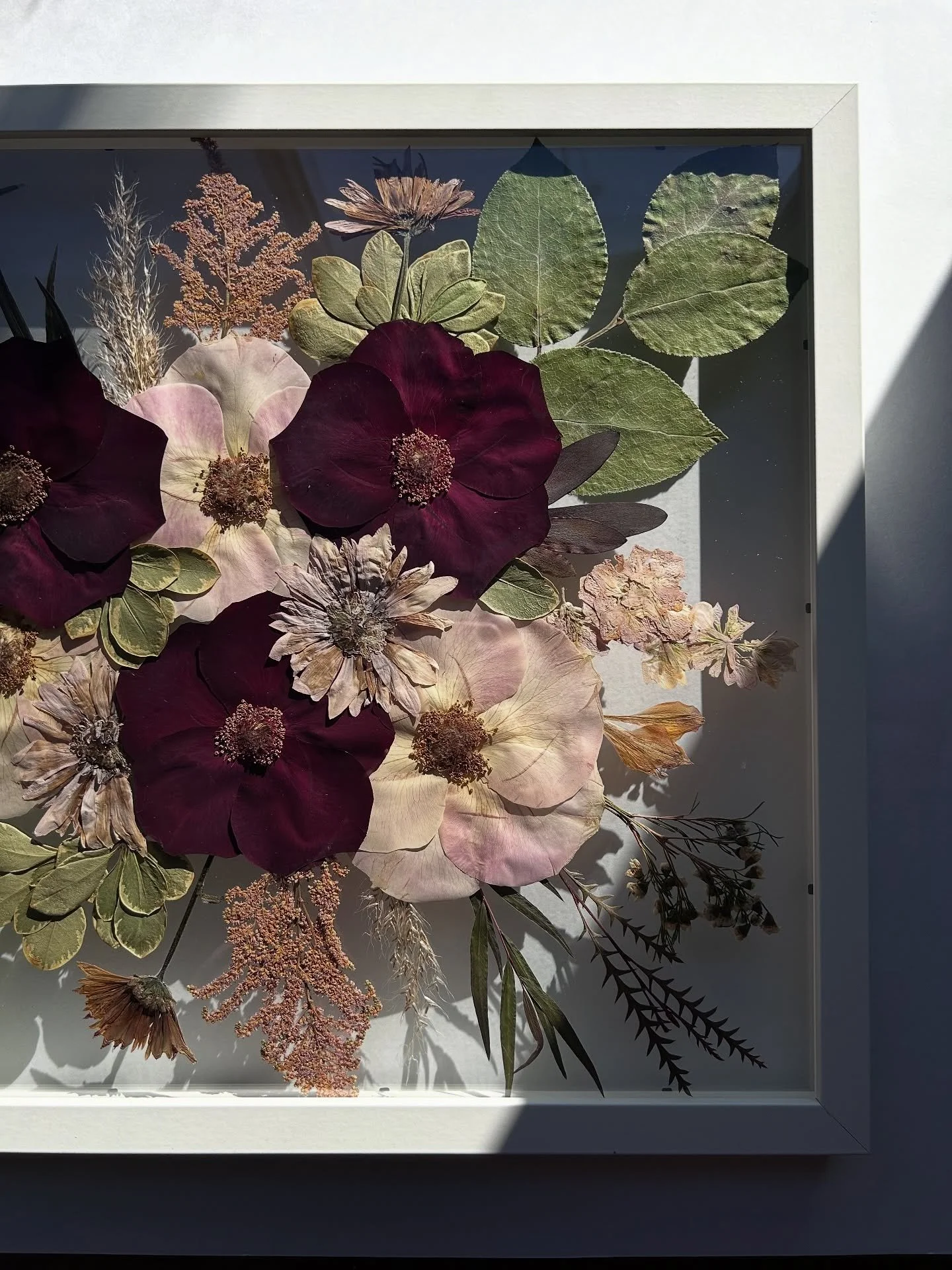 This pressed bouquet for my sweet bride Mackenzie turned out absolutely stunning 🤍 She chose a 16x20 white float frame filled with the dreamiest fall tones &mdash; dark reds, petal pinks, and soft neutrals. Such a timeless way to preserve those wedd