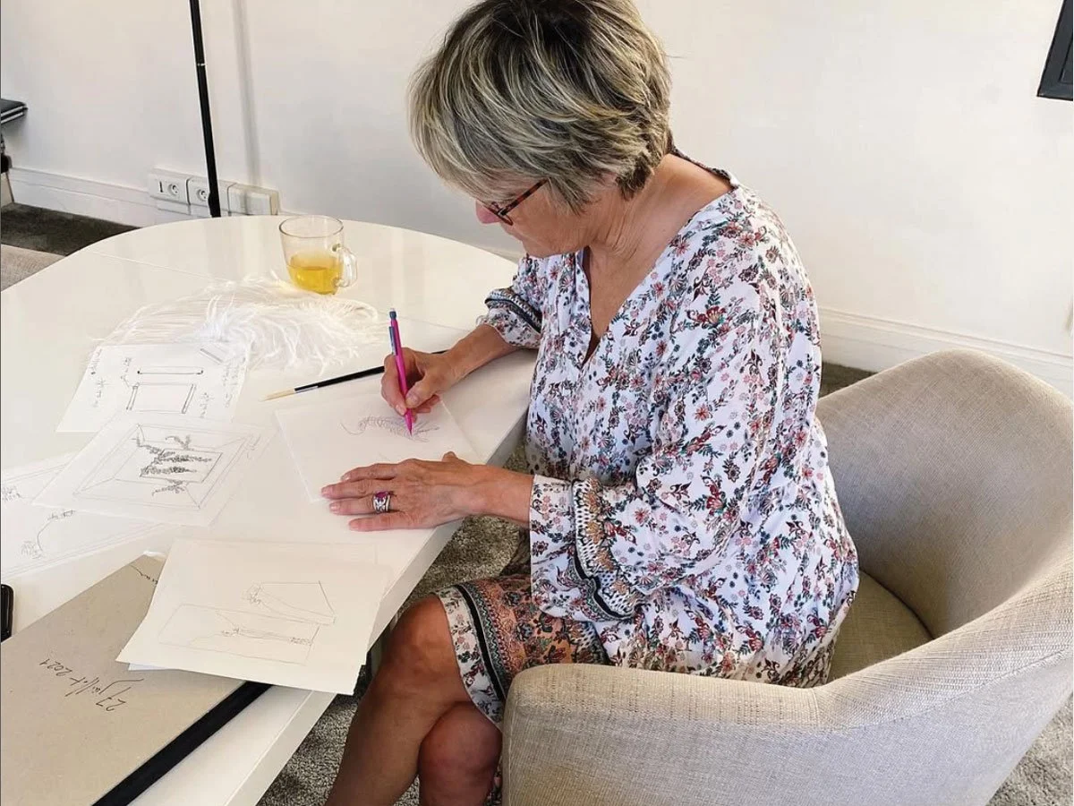 Edeenne sitting at desk drawing jewelry portraits