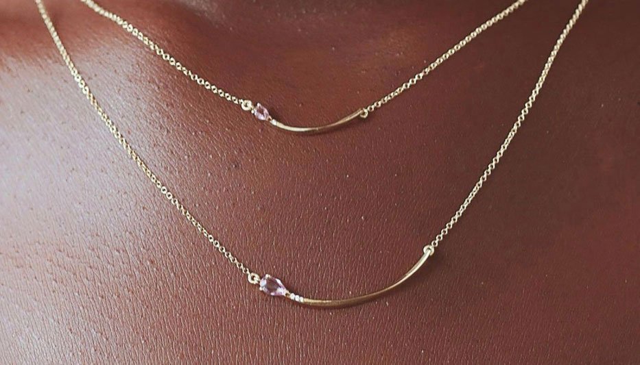 sapphire and gold layering necklaces worn on woman's neck