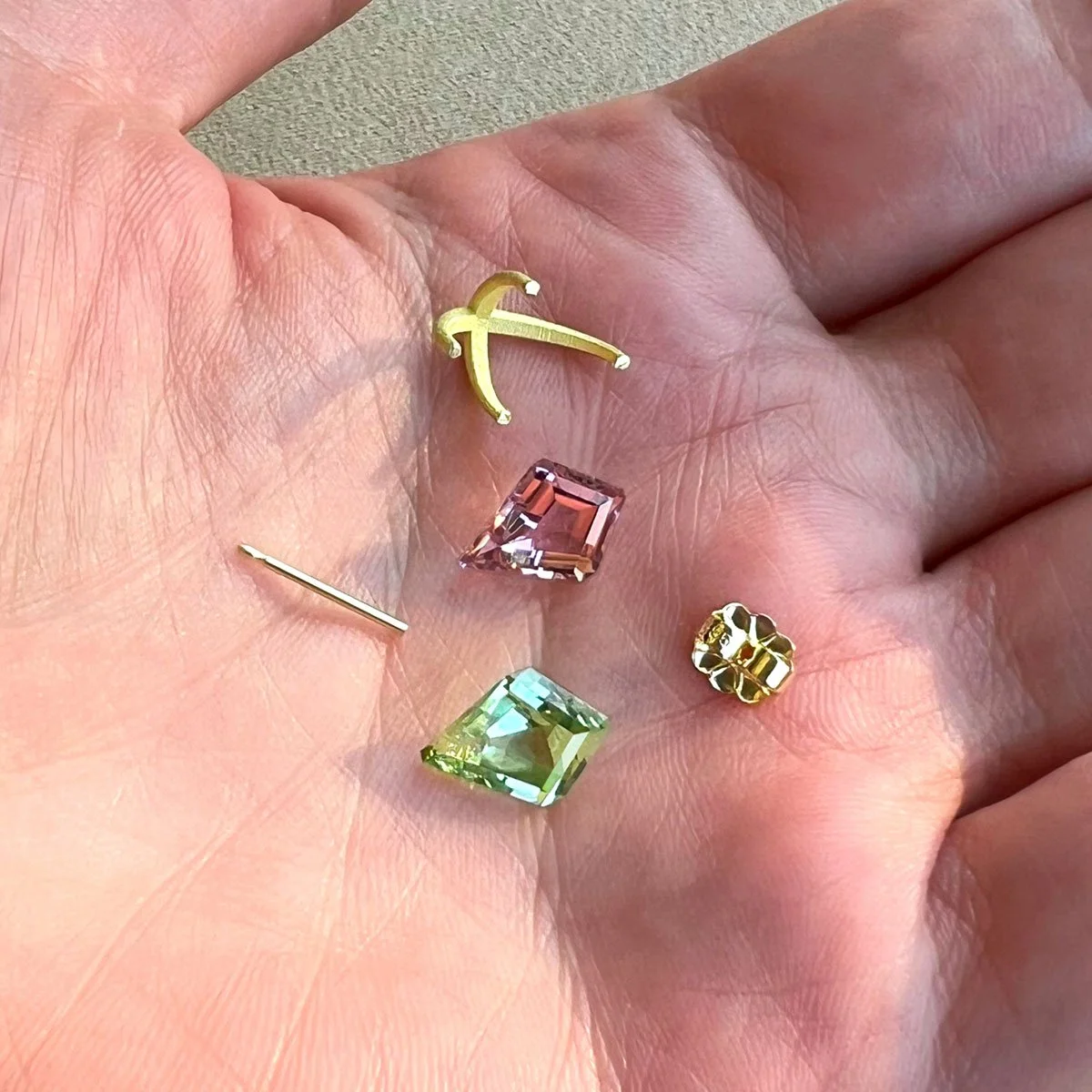 Mismatched Colored Gemstones and Gold Studs on Hand Behind the Scenes