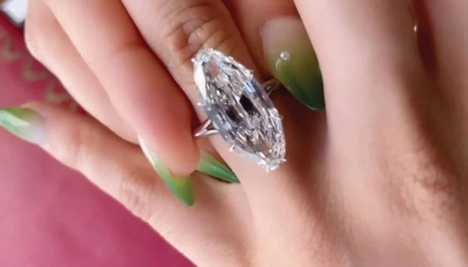 Big diamond engagement ring being put on finger