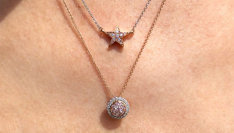 two Argyle Pink Diamond layering necklaces worn on woman's neckl