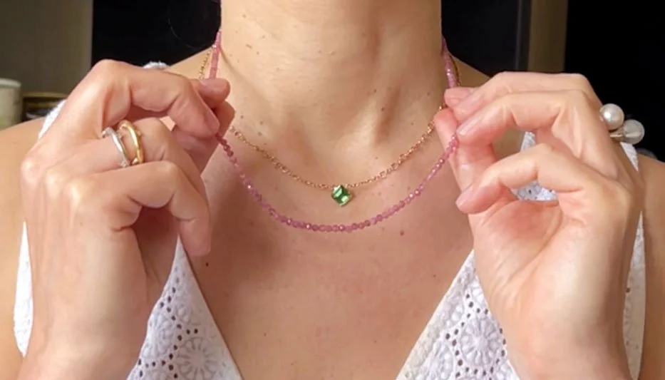 woman holding gemstone layering necklaces
