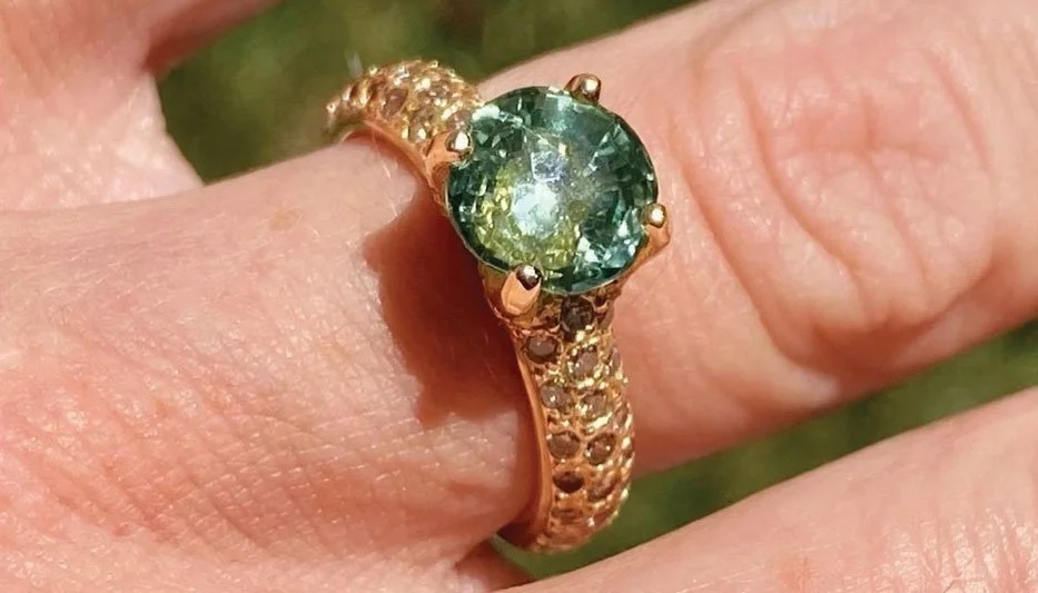 green gemstone ring worn on woman's finger