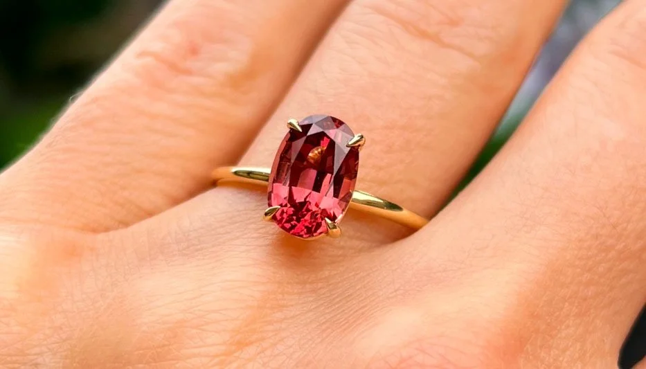 red gemstone ring worn on woman's hand