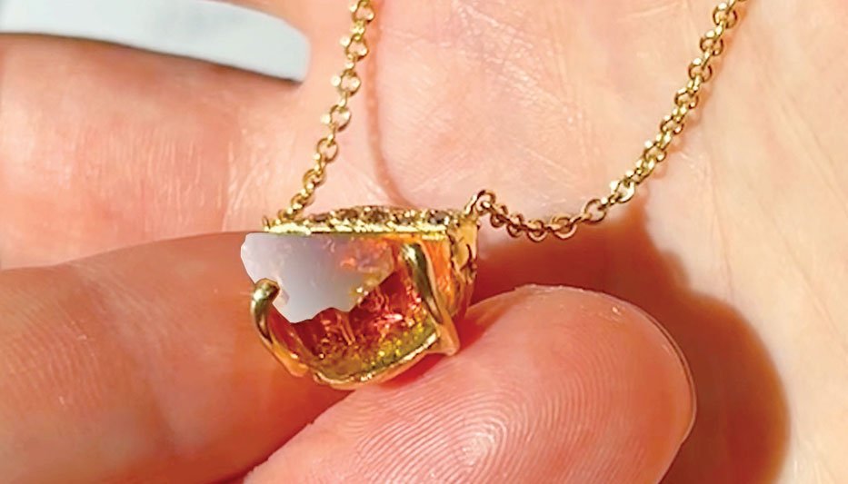 pink tourmaline necklace held in woman's hand