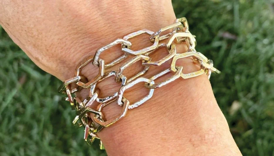 gold link bracelet stack on woman's wrist