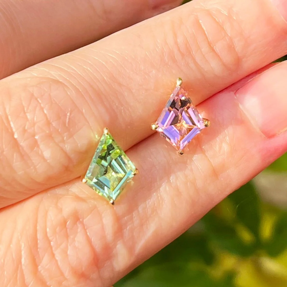 Tourmaline Mismatched Earrings Held Between Women's Fingers