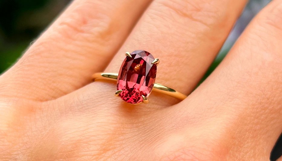 red gemstone engagement ring on woman's finger