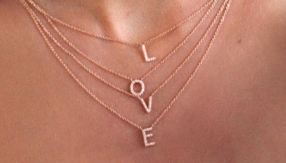 layered initial necklace stack spelling out LOVE