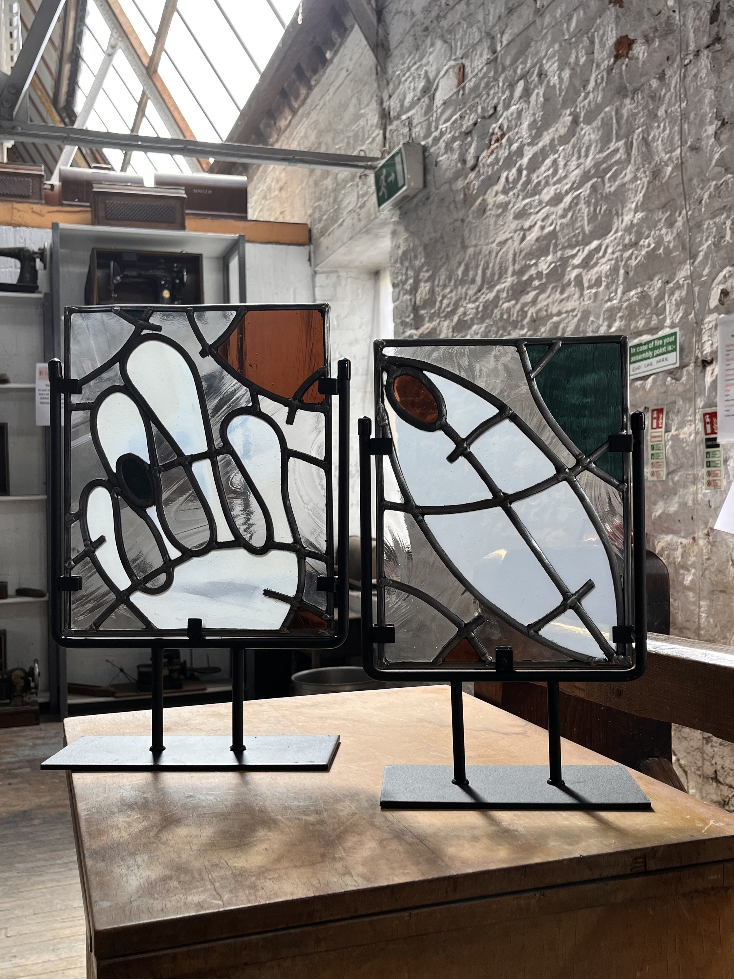 stained glass sculptures of seedpods open and closed.