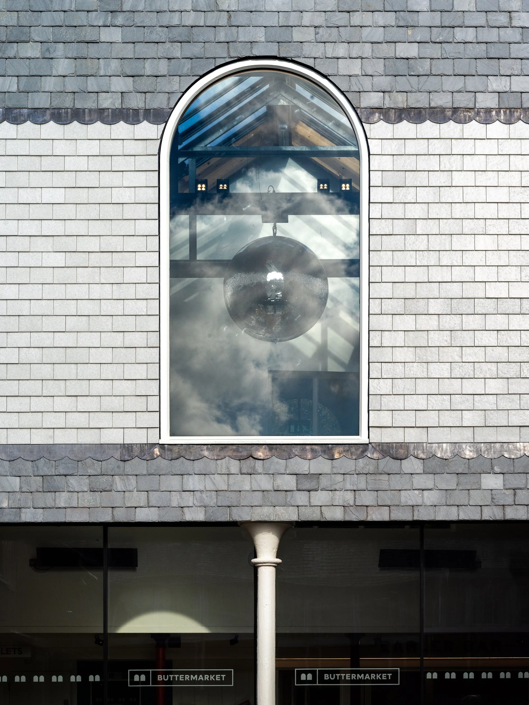 Close-up view of the recycled glass at the Buttermarket, showing a window framed by white recycled glass tiles and grey slate. Photo: Claire Fear