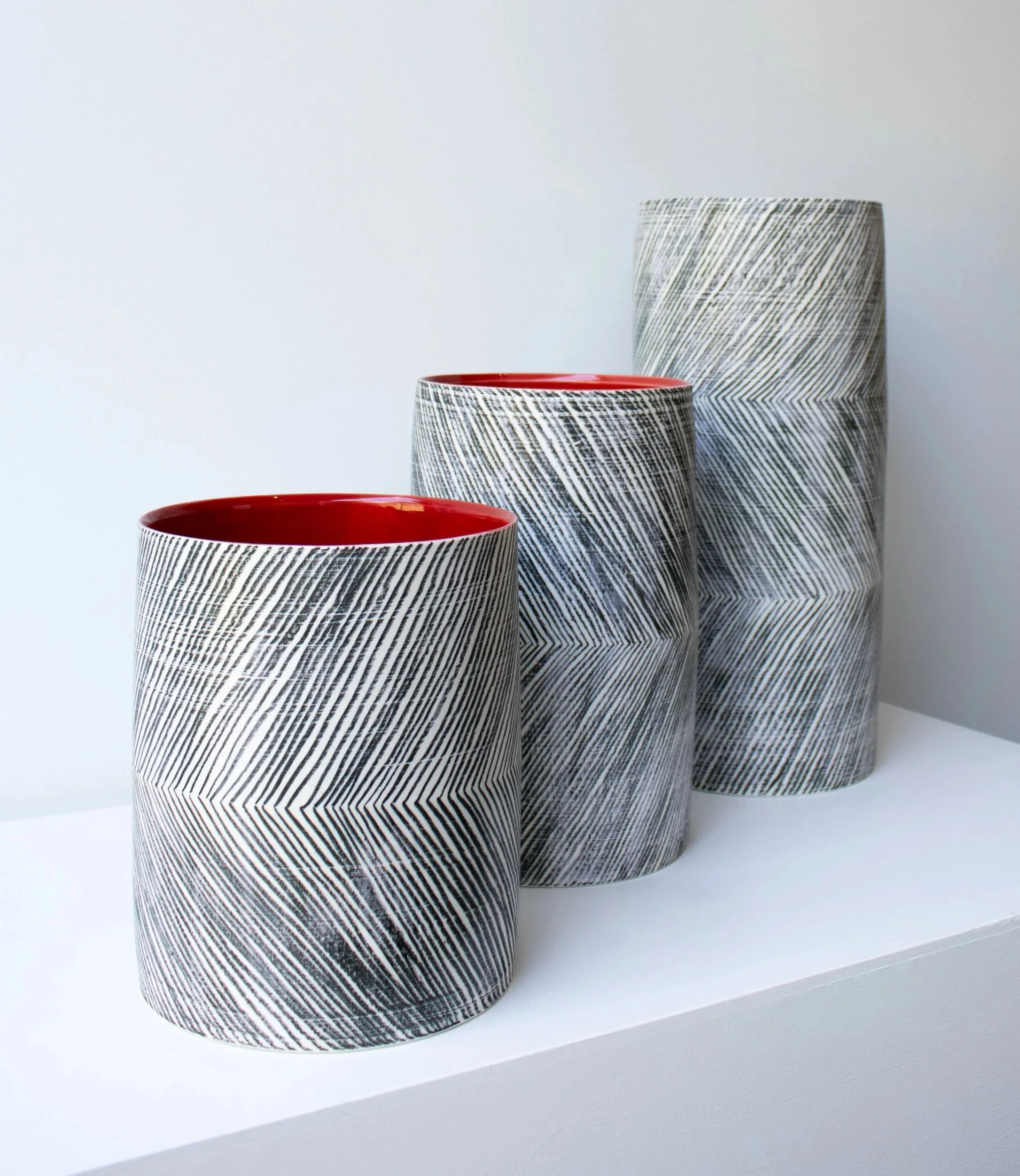 Porcelain vessels with a red glaze interior
H38 x  Dia 17cm, H27 x  Dia 17cm and H22 x  Dia 17cm
