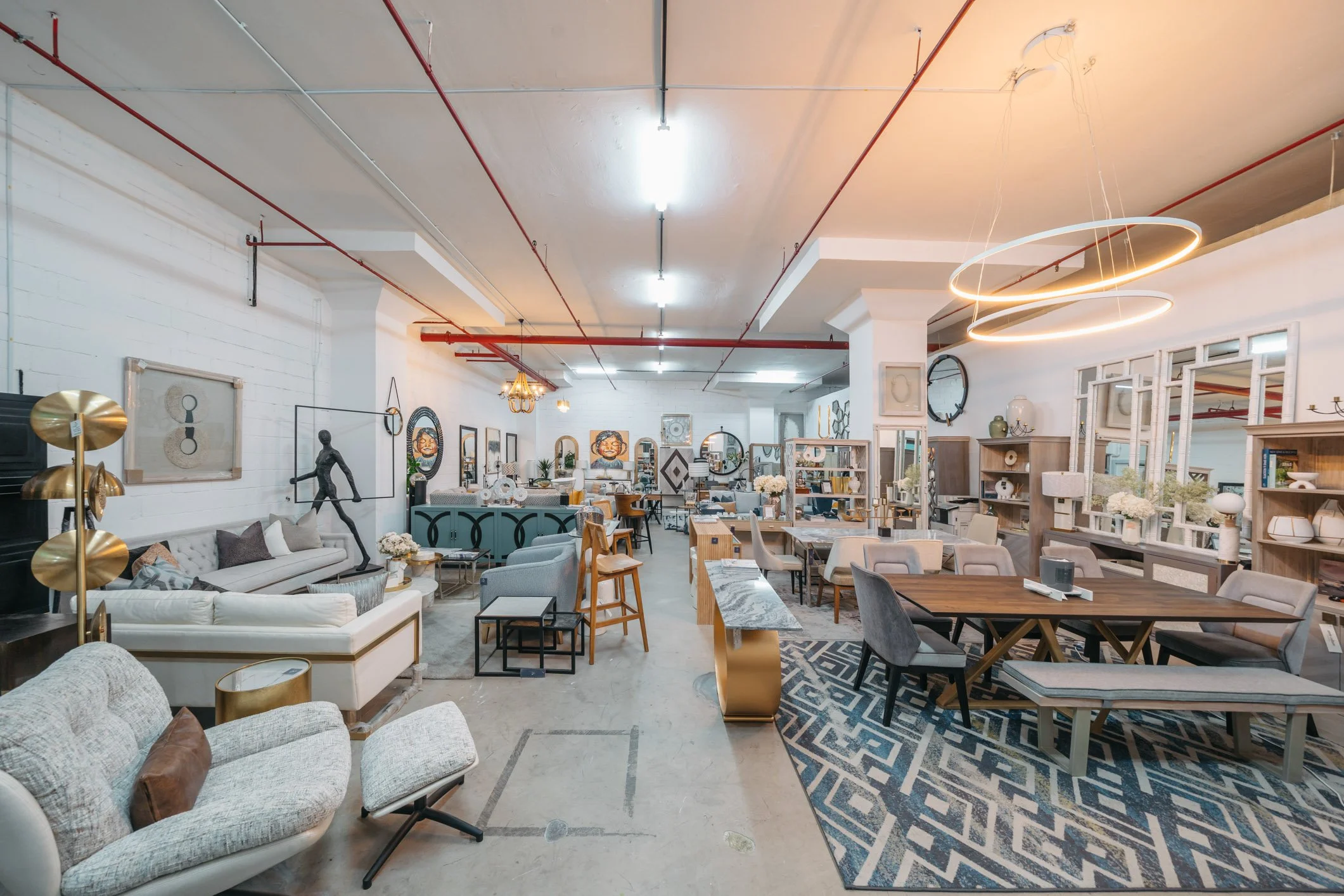 High-quality furniture and luxury interior design pieces displayed in a spacious, modern showroom in Singapore, featuring contemporary sofas, marble tables, and designer lighting.