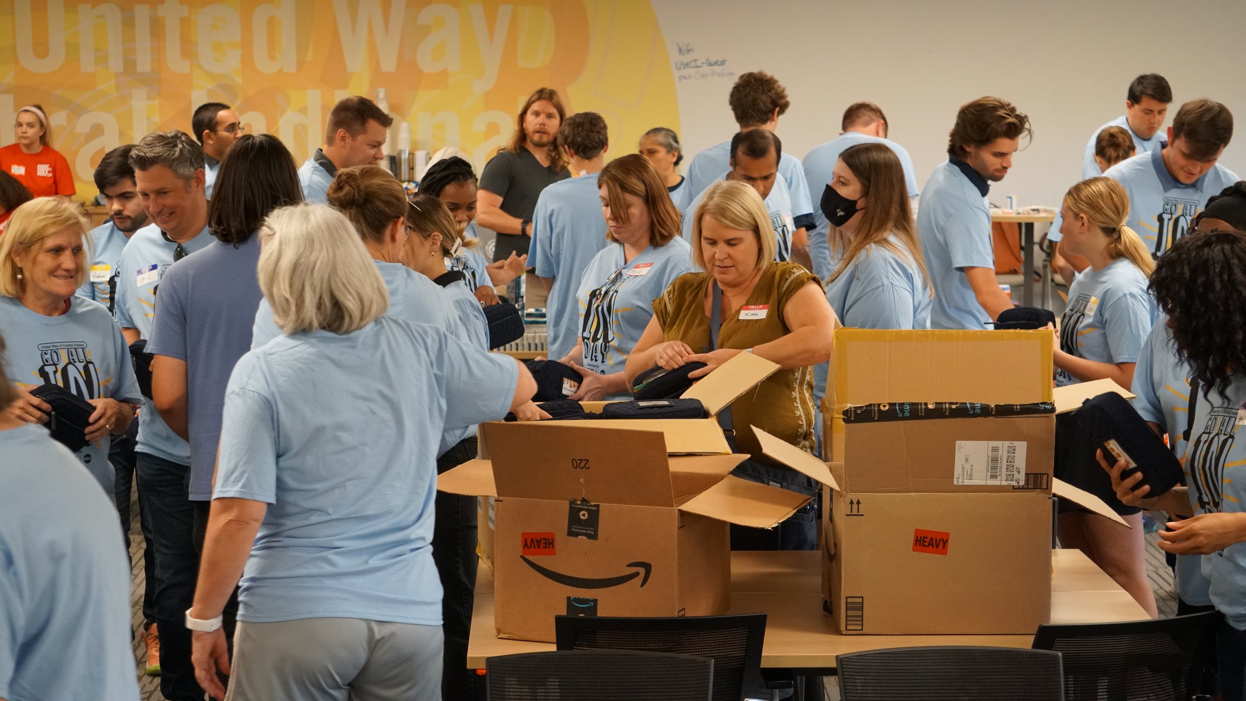  Volunteers stuff bags with school supplies at United Way of Central Indiana’s headquarters on June 24, 2022, for Go All IN Day. The bags will go to kids participating in Indy Parks camps this summer.  