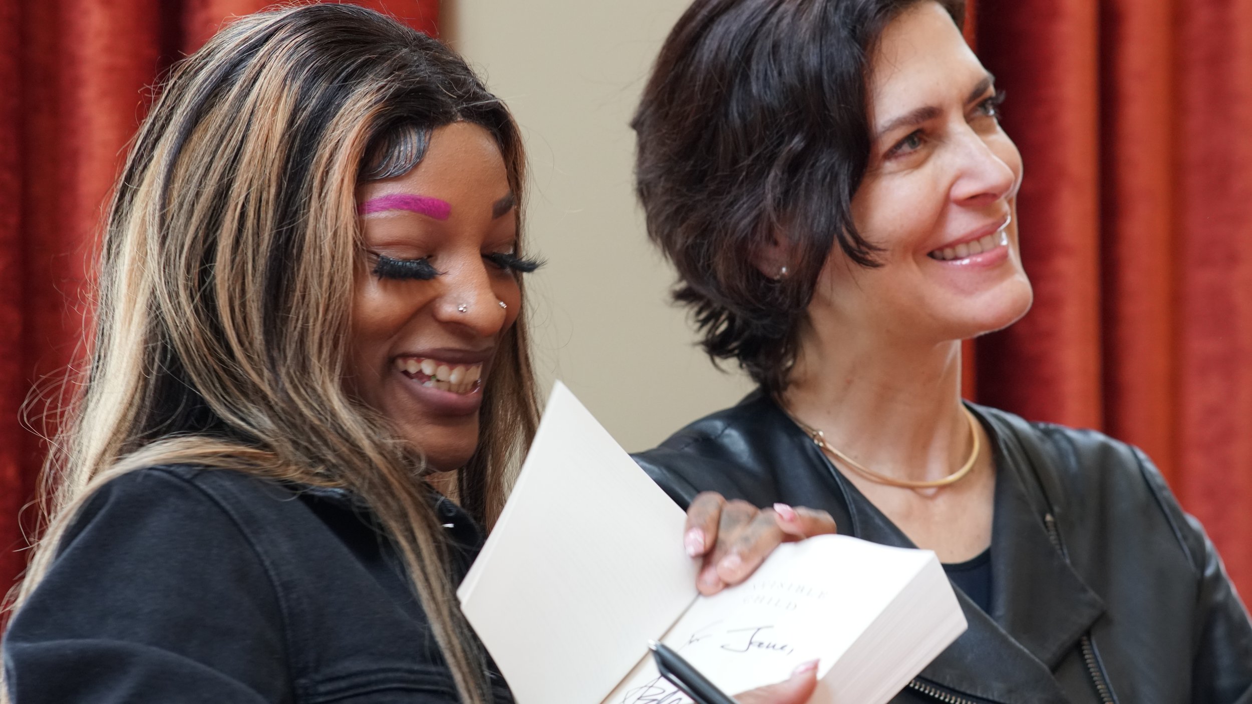  Dasani Coates (left) and Andrea Elliott sign copies of “Invisible Child: Poverty, Survival and Hope in an American City” on March 5, 2024, at Indiana Landmarks. The two spoke at a United Way of Central Indiana event. 