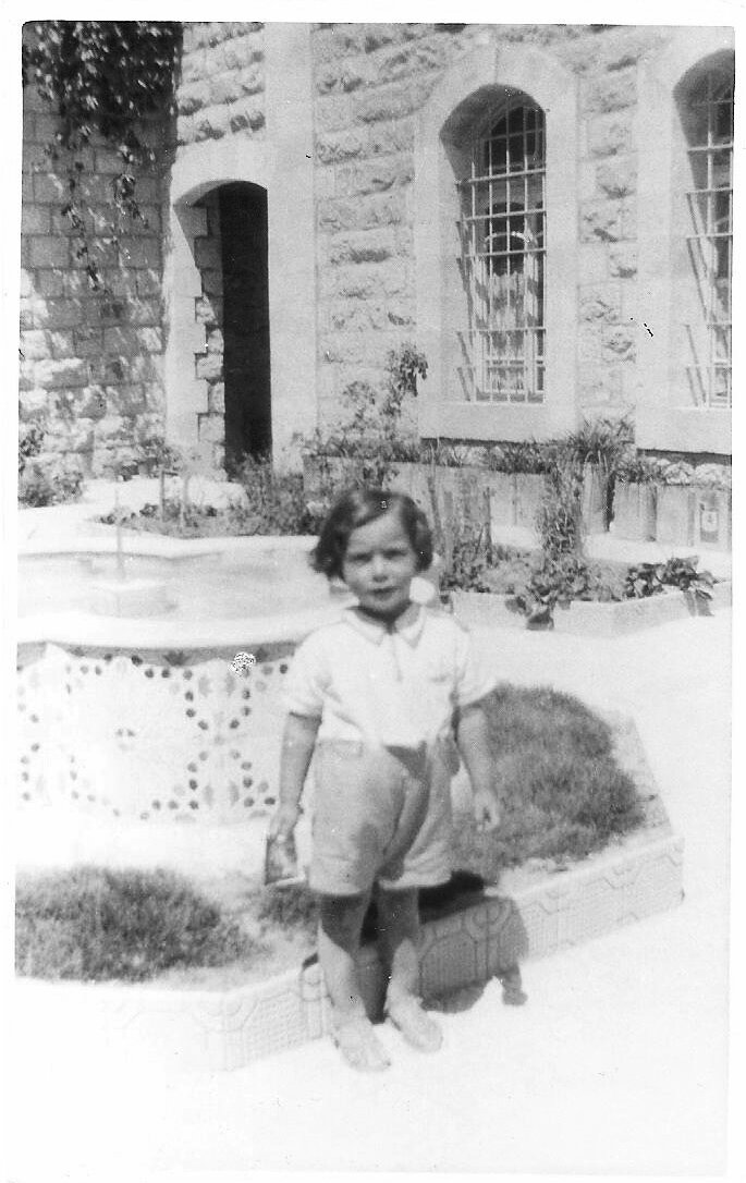 Unknown child in the front garden with the home and archway (demolished) seen behind