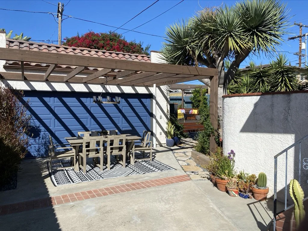 Blue garage door, garage conversion, outdoor living, open pergola design