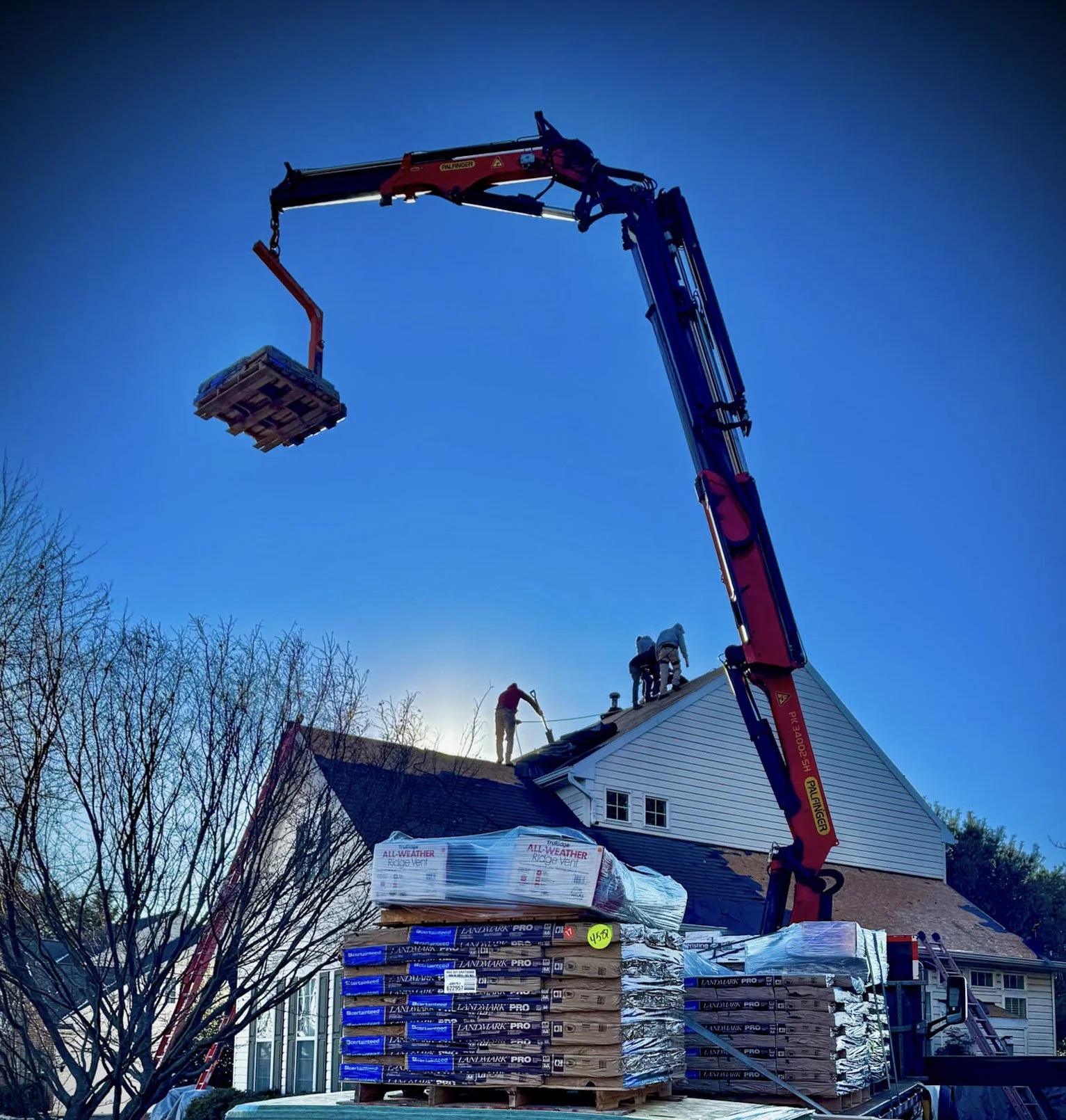 Country View Builders using a crane truck for a roof top delivery in Cooksville, Howard County. A new roof is being installed.
