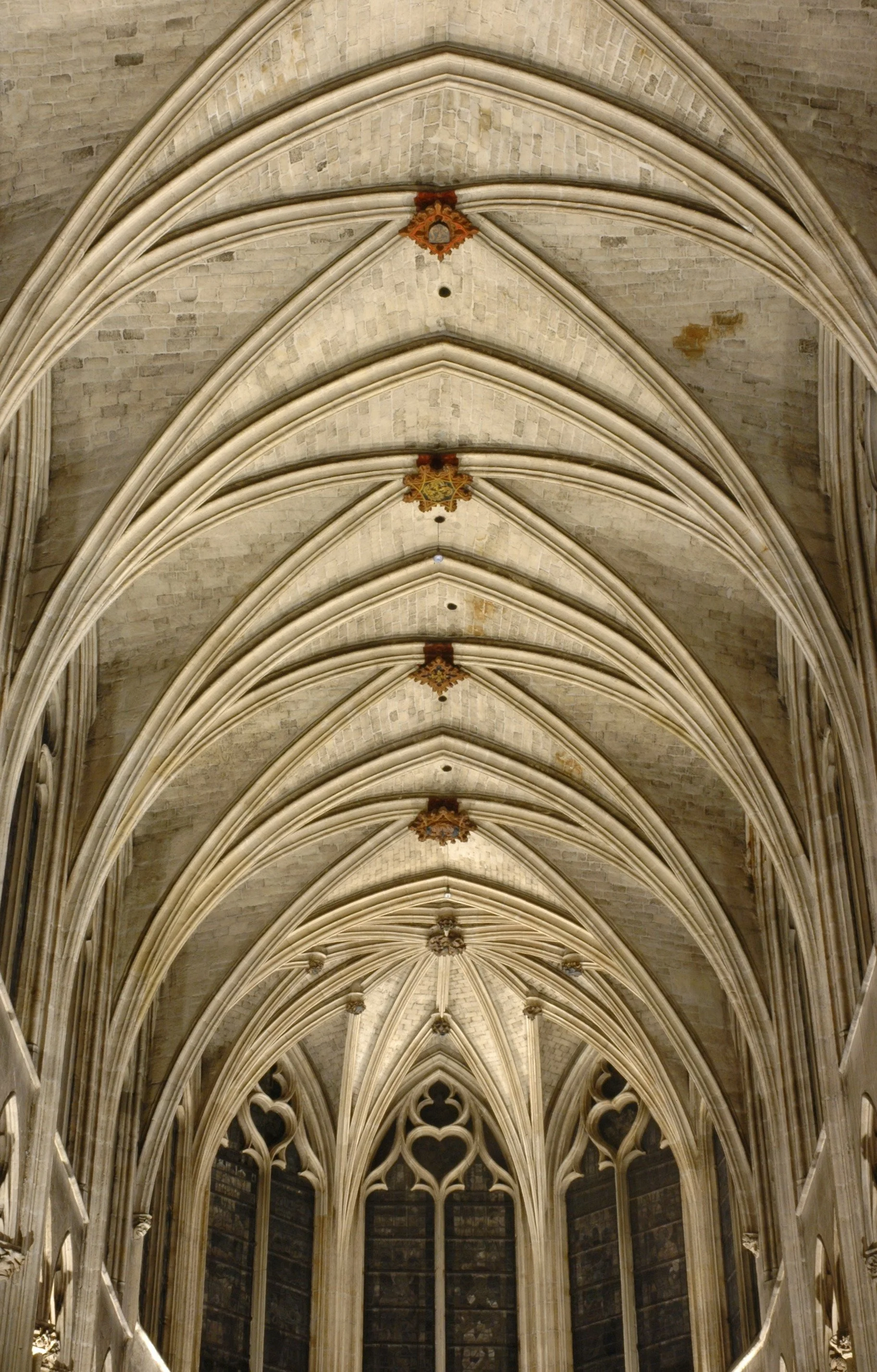 A Gothic cathedral ceiling with pointed arches and intricate stone tracery.