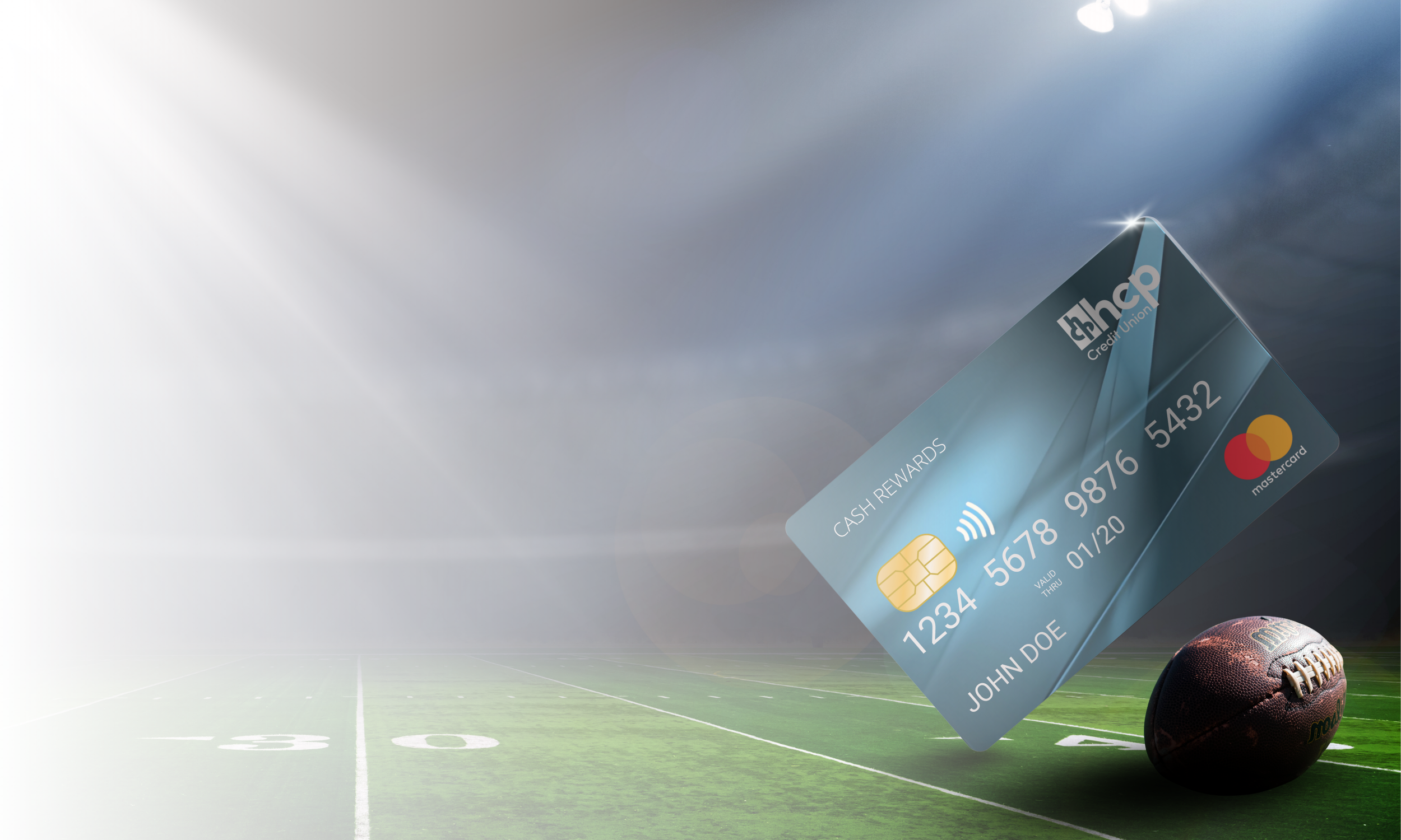 HCP Credit Union Cash Rewards Mastercard credit card displayed over a football field under stadium lights, with a football in the foreground.