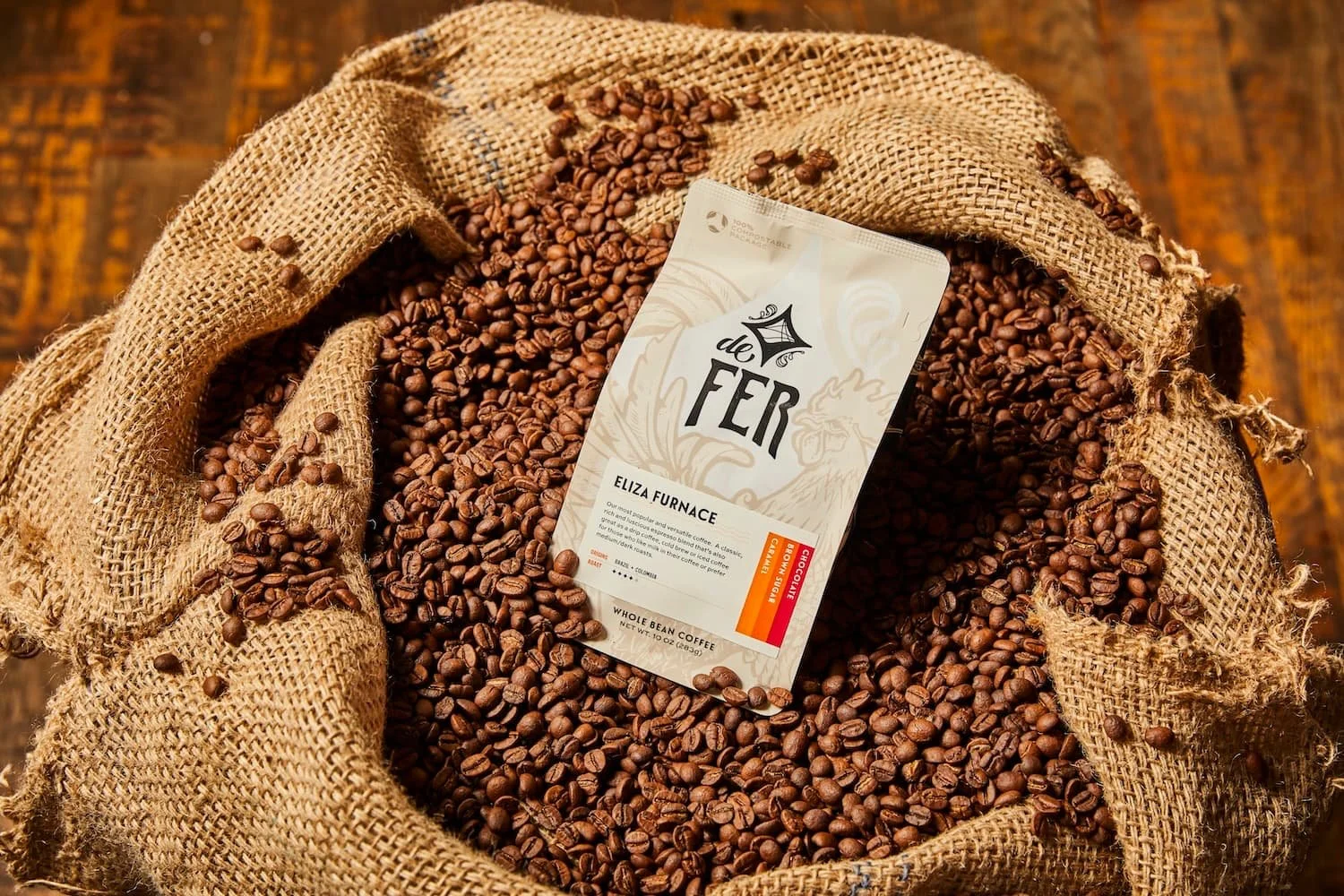 bag of whole bean coffee, placed in burlap bag filled with coffee beans