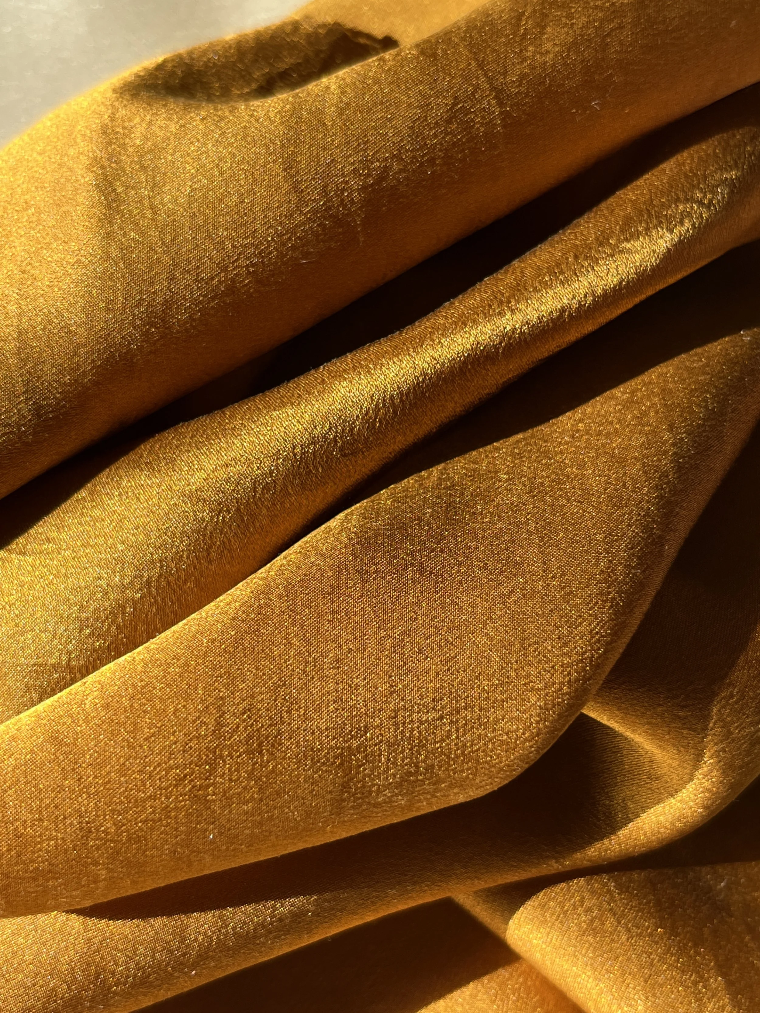 Close-up of gold velvet silk with soft folds and texture